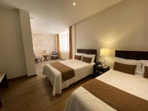 萨卡特卡斯Hotel Casa Faroles Centro Histórico的酒店客房带两张床和一个客厅