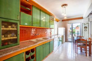 斯塔夫罗斯ISTORIA Residence的厨房配有绿色橱柜和水槽