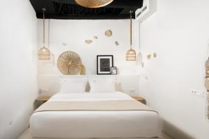 赫索尼索斯Icos village house的一间卧室配有一张带白色墙壁和吊灯的床。