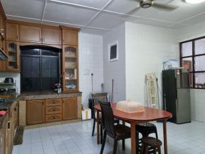 米里Kenyalang Lutong Homestay的厨房配有桌椅和冰箱。