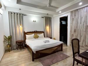 新德里Avatar Living @Safdarjung Enclave的卧室配有一张床和一张桌子及椅子