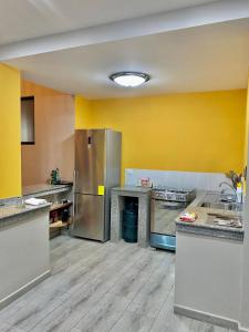 阿约拉港Suites Hermosas cercanas a todo的厨房设有黄色的墙壁和不锈钢用具