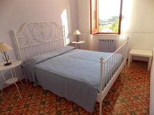 马尔萨拉Holiday home Mediterraneo的一间卧室设有床、两张桌子和一扇窗户