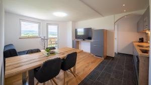 圣卡尼兹Apartments Presslauer - Mori的厨房以及带木桌和椅子的用餐室。