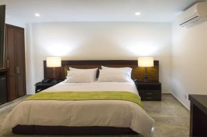 布卡拉曼加帕隆格酒店的一间卧室配有一张大床和两盏灯