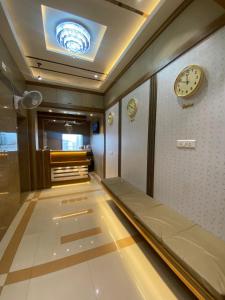 孟买Hotel BKC CROWN - Near Trade Centre, Visa Consulate的走廊上设有一张床和墙上的时钟