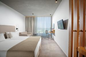 马尔马里卡拉维尔海滩酒店的酒店客房设有一张大床和一张书桌。