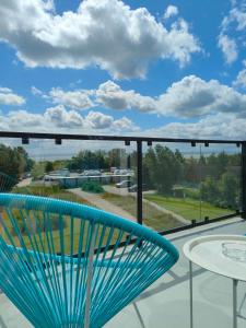 亚斯塔尔尼亚Apartamenty Mistral的蓝椅位于阳台的顶部,享有风景。