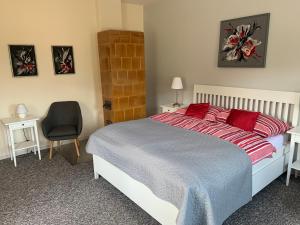 利普托斯基米库拉斯Domcek pri Medokysi的一间卧室配有一张带红色枕头的床和一把椅子