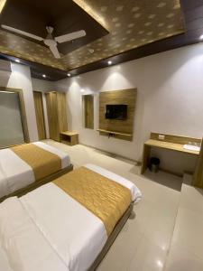 孟买Hotel BKC CROWN - Near Trade Centre, Visa Consulate的一间卧室配有两张床和一台平面电视