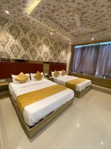 孟买Hotel BKC CROWN - Near Trade Centre, Visa Consulate的一间卧室设有两张床,天花板设有