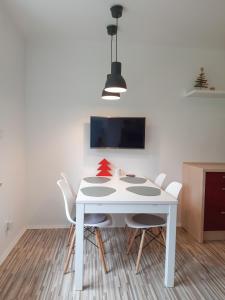 拉姆绍达赫斯坦Apartman Ramsau的白色的餐桌、椅子和电视
