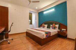 新德里FabHotel Lime Tree的一间卧室设有一张床和蓝色的墙壁