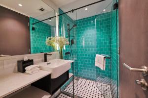 吉隆坡J-Hotel by Dorsett的浴室设有水槽和绿色瓷砖淋浴。