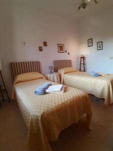 RegalbutoVilla Guido的一间卧室配有两张床,配有橙色床单