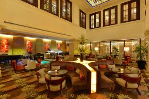 胡志明市Equatorial Ho Chi Minh City的酒店大堂设有沙发和桌子。