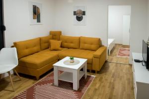 维舍格勒Apartmani Pijemont的客厅配有黄色的沙发和桌子
