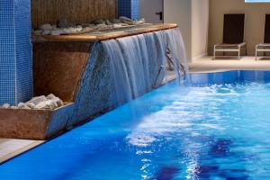 米苏丽娜密苏里纳大酒店的一座位于酒店客房的带瀑布的游泳池