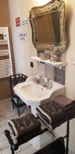 La Maison de Manon的浴室配有带镜子的盥洗盆和毛巾