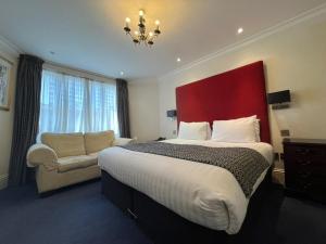 伦敦广场酒店的酒店客房带一张大床和一把椅子