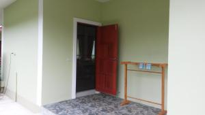 三百岭班汗里玛度假屋的一间设有红色门和桌子的房间
