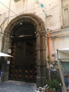 那不勒斯Royal Boutique Napoli的一座带大木门的建筑的入口
