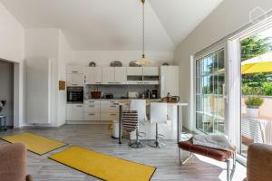 哈恩Charmantes Loft Appartement的厨房配有白色橱柜和黄色地毯桌