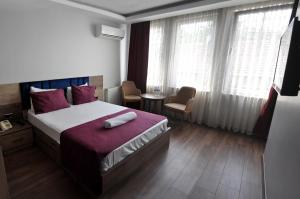 伯萨Waha Hotel的酒店客房带一张床、一张桌子和窗户