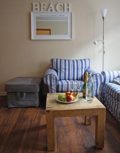 于斯德Inselresidenz Strandburg Juist - Wohnung 106 (Ref. 50958)的客厅配有沙发和带果盘的桌子