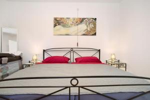 腓特烈港Haus Rosi的一间卧室配有一张带红色枕头的大床