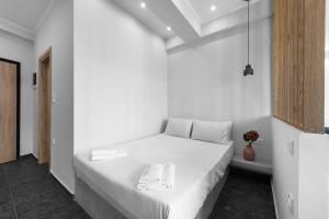 塞萨洛尼基WallStreet, The Luxury Suites的白色卧室配有白色床单