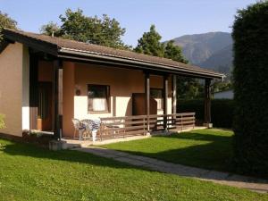 克查赫克恩顿州阿尔卑斯山营地酒店的房屋设有门廊,配有桌椅