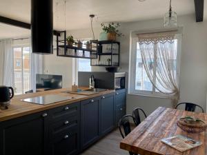 圣波拉SunPola Penthouse的厨房配有蓝色橱柜和木桌