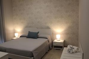 普拉亚·阿马勒Albadorata的一间卧室配有一张床和两张带台灯的桌子。