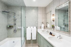 迈阿密海滩National Hotel, An Adult Only Oceanfront Resort的浴室配有2个盥洗盆、浴缸和淋浴。