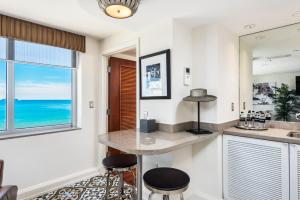 迈阿密海滩National Hotel, An Adult Only Oceanfront Resort的厨房配有柜台、两张凳子和窗户