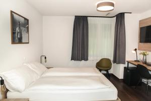 迪本多夫Dihei - Hotel, Lounge, Bar的一间酒店客房,配有一张白色的床和一张书桌