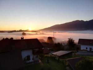 哈尔布莱希Opas Bergchalet的享有一个雾 ⁇ 的小镇的景色,背面是太阳