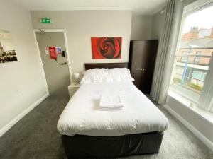 哈特尔普尔OYO Studiotel Hartlepool的卧室配有一张大白色床和窗户