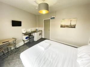 哈特尔普尔OYO Studiotel Hartlepool的卧室配有一张白色大床和一张书桌