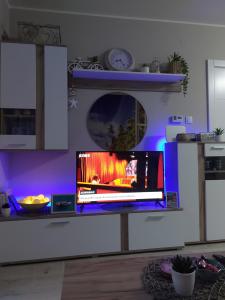斯雷姆斯卡米特罗维察# Espresso 2 Apartman sa garazom的紫色灯厨房里台上的电视