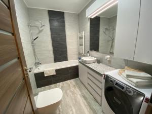 奥拉迪亚Top Level Residence的一间带水槽和洗衣机的浴室