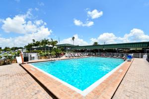 萨拉索塔Sarasota Cay Club #612 - Heated Pool, Bunk Beds, Huge TV, Tiki Bar, More!的一座带椅子的大型游泳池和一座建筑