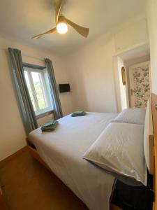 卡莫利Appartamento Victoria的卧室配有白色的床和吊扇