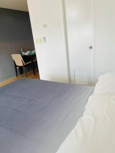 BiñanStudio Type Condo with WiFi的卧室配有白色的床和桌椅