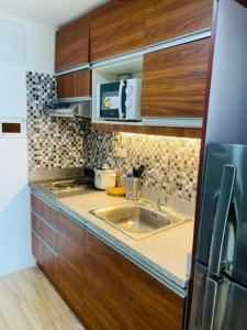 BiñanStudio Type Condo with WiFi的一个带木制橱柜和水槽的厨房