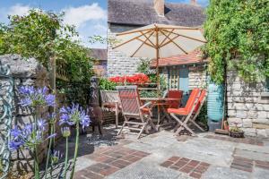 斯沃尼奇Passiflora Cottage的庭院配有桌椅和遮阳伞。