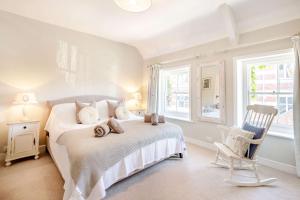 斯沃尼奇Passiflora Cottage的一间卧室配有一张床、一把椅子和窗户。