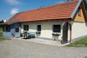 阿尔戈伊地区洛伊特基希Ferienwohnung Kleiner Spatz的白色的建筑,有橙色的屋顶和桌子