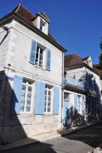 欧塞尔圣佩雷斯住宿加早餐旅馆的一条白色的老建筑,在街上有蓝色百叶窗